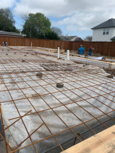 grid of metal poles for house foundation